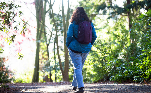 A person walking in a park with a Luminary 15.